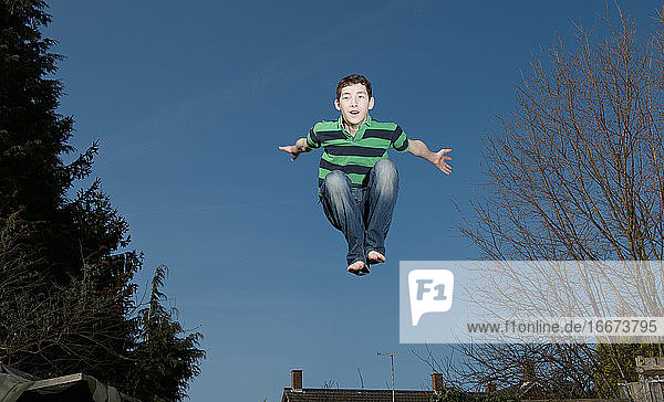 Junge springt auf Trampolin in Woking - England