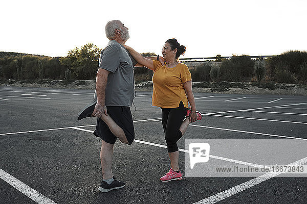 A middle-aged couple are doing stretching exercises together