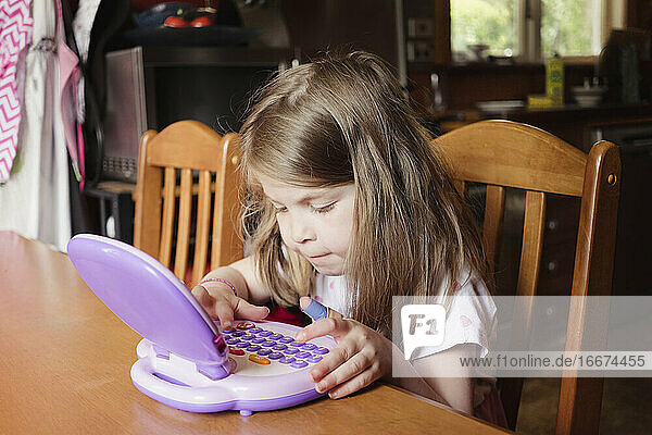 Junges Mädchen spielt am Tablet in der Vorschule