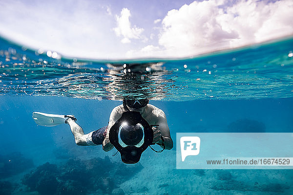 Unterwasserfotograf in Split-Level-Foto auf sonnigen Hawaii Tag