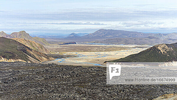 Islands vulkanische schwarze Felslandschaft mit Flüssen und moosbewachsenen Hügeln