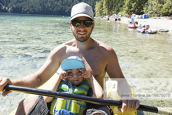 Father and son enjoying a beach day in their inflatable kayak