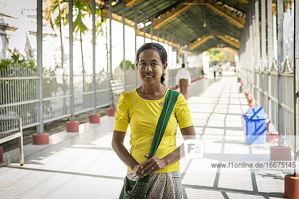 Portrait of smiling woman with leaves markings on her face made by thanaka  Mandalay  Myanmar