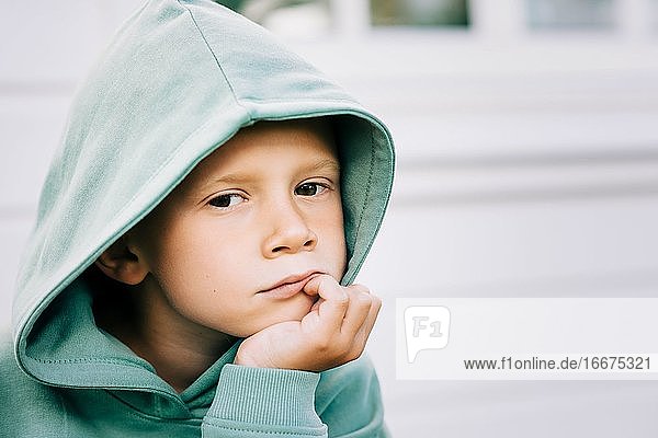 close up portrait of a boy with his hood up