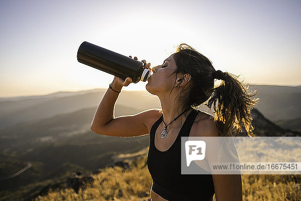 Nahaufnahme einer jungen Sportlerin  die Wasser aus einer Flasche trinkt