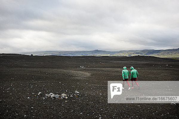Hikers explore a black sand beach near Vik  Iceland.