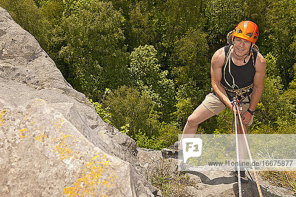 man rappelling of cliff in south Wales