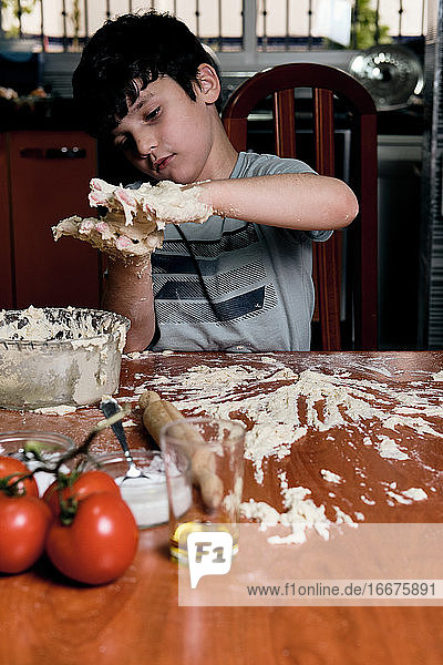 Junge bereitet zu Hause Pizzateig zu
