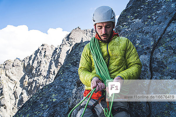 Ein Bergsteiger überprüft seinen Knoten während einer Klettertour in Washington