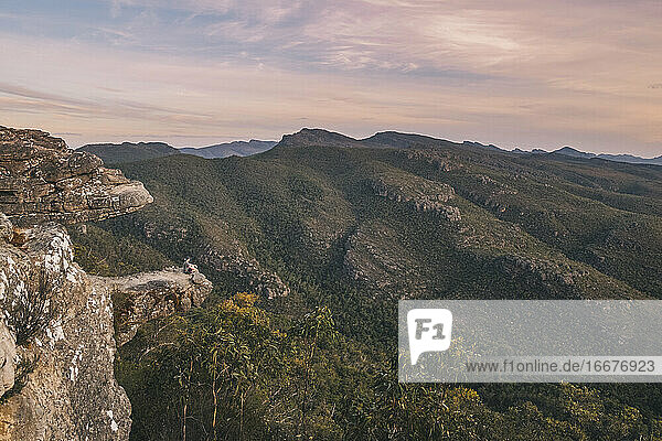 Young man sitting at the Balconies viewpoint during sunset  Grampians National Park  Victoria  Australia