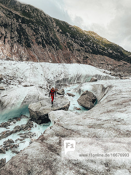 Junge Bergsteigerin bei der Flussüberquerung auf dem Gletscher Mer de Glace