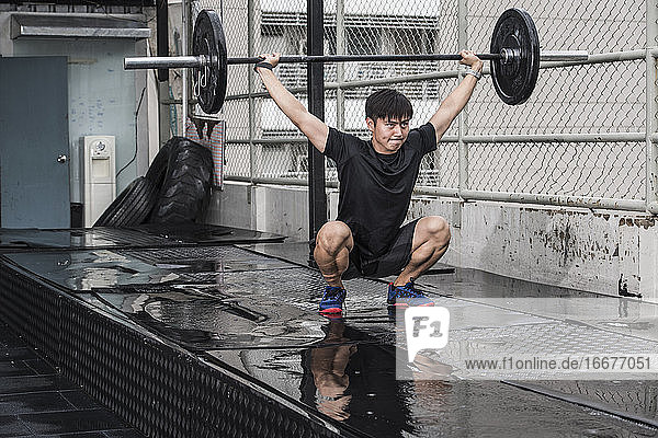 Mann trainiert auf dem Dach eines Fitnessstudios in Bangkok