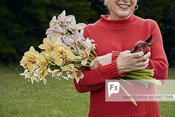 Lächelnde Großmutter mit frischen Schnittblumen aus dem Garten