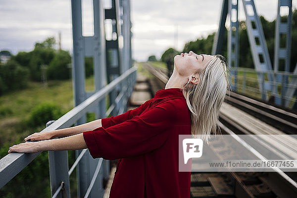 Blonde Frau auf Eisenbahnbrücke