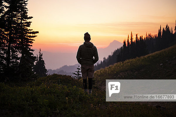Silhouette of male watching colorful sunset in the cascade mountains