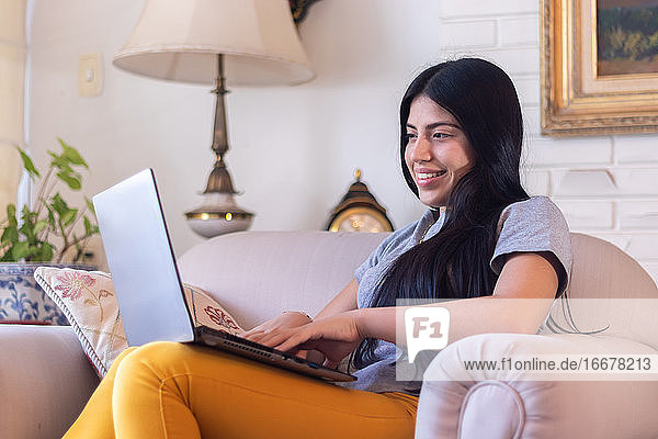 Frau benutzt ihren Laptop zu Hause wegen Coronavirus-Quarantäne