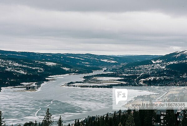 Blick über einen schneebedeckten See und Berge in Nordschweden