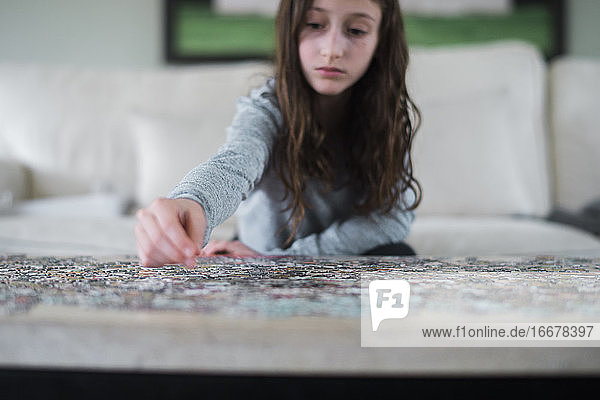 Junges Mädchen arbeitet an einem Puzzle in einem Haus