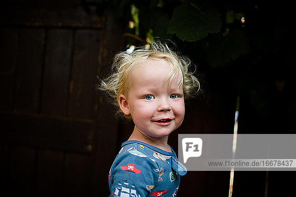 Blondes zweijähriges Kind im Schlafanzug lächelt für die Kamera
