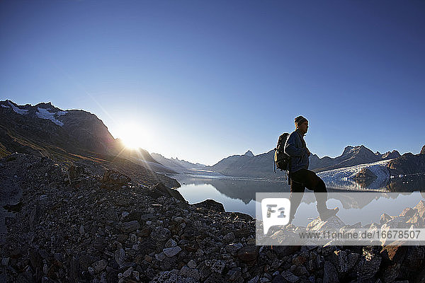 Mann beim Wandern an einem Fjord in Ostgrönland