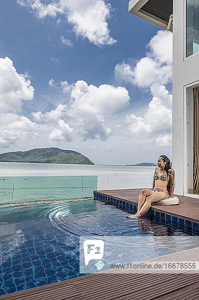 schöne Frau am Pool einer Luxusvilla in Phuket