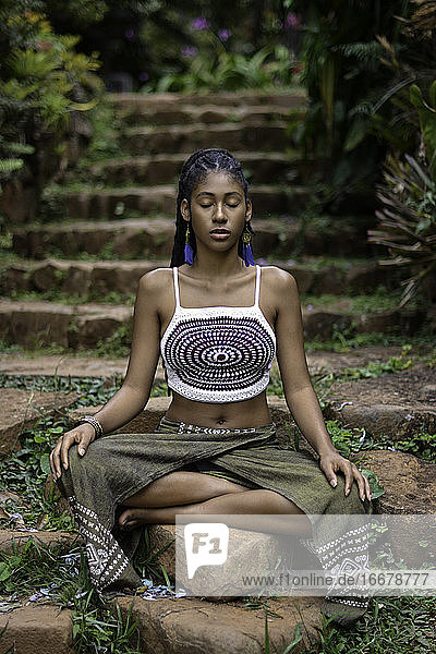 Junger Afro-Kolumbianer sitzt in Lotus-Pose