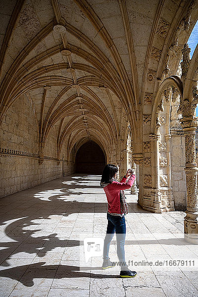Reisende Frau beim Fotografieren eines antiken Gebäudes