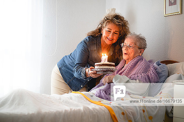 Alte Frau und Tochter feiern ihren 97. Geburtstag mit einer Torte