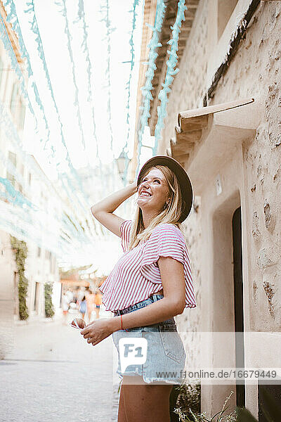 Happy blonde woman with hat enjoying tourism in Majorca
