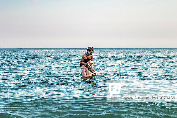 5 Jahre altes Kind auf den Schultern seiner Mutter  im Ozean