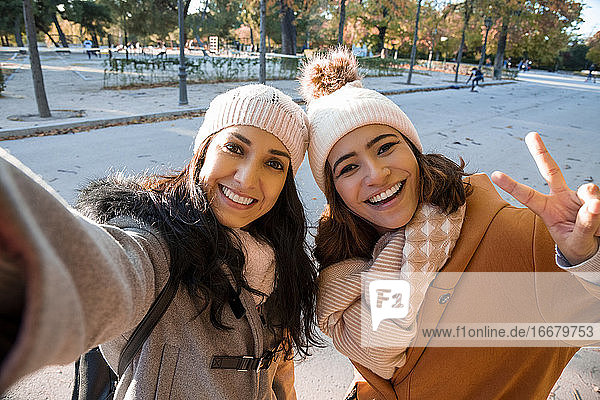 Best friends taking a self-portrait in the park in the fall