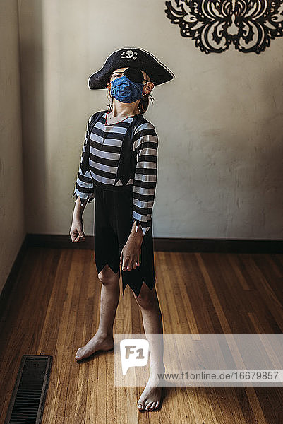 Full length of young boy dressed as pirate with face mask on