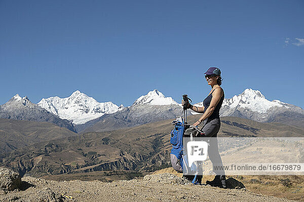 Eine Frau macht eine Pause beim Wandern in der Cordillera Blanca