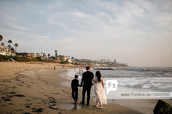 Newlyweds & Nine Year Old Son Walking Along Beach in San Diego