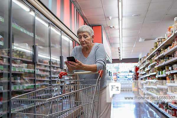 Kaukasische ältere Frau mit weißem Haar beim Einkaufen im Supermarkt