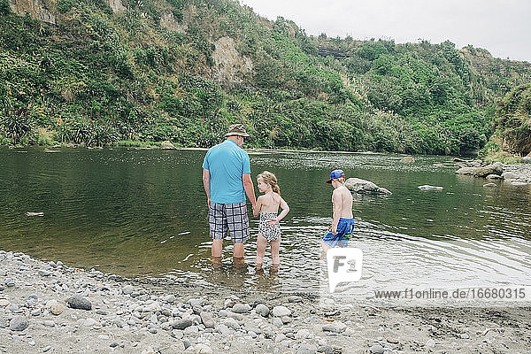 Familie beim Spielen im Wasser an einem malerischen Flussabschnitt