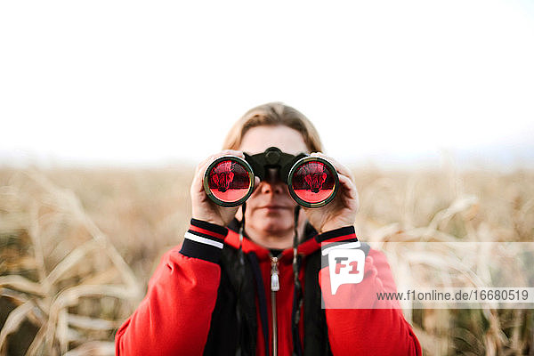 woman holding binoculars at farm