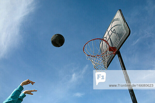 Basketball in der Luft gegen blauen Himmel