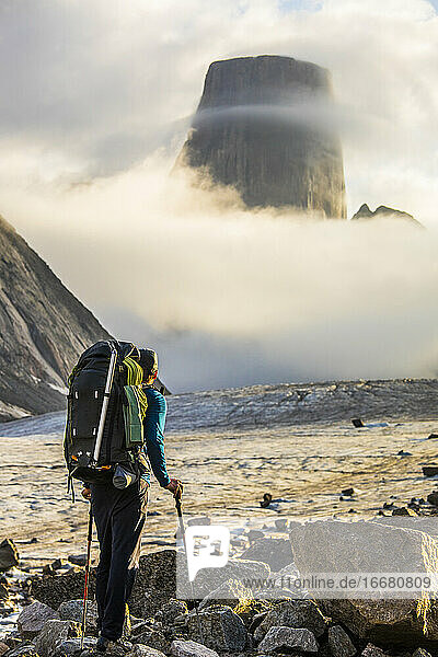Backpacker looking up at the summit of Mount Asgard  Baffin Island.
