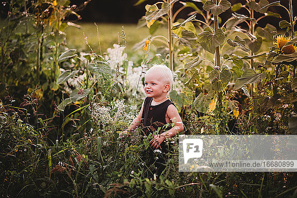 Lächelndes Kleinkind inmitten eines Blumenfeldes