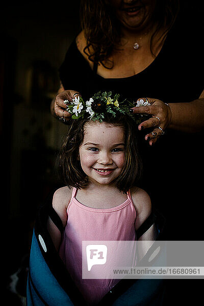 Tante setzt ihrer Nichte eine Blumenkrone auf den Kopf