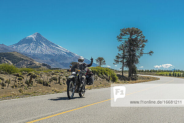 Woman on touring motorbike. Lanin volcano in the back  Argentina