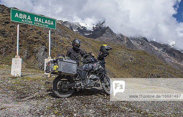 Woman standing by her motorbike at Abra de Malaga pass (4316 m.s.n.m.)