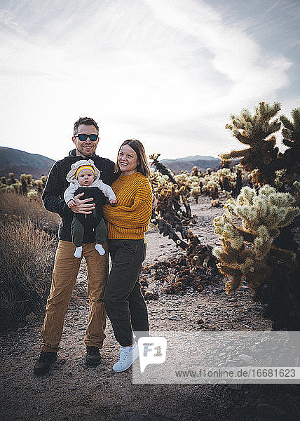 A family is standing near a cactus in the desert  California