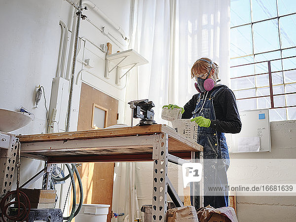 Professionelle Bildhauerin bei der Arbeit mit Gips in ihrem Atelier