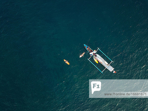 Aerial view of surfers and boat in the ocean  Lombok  Indonesia