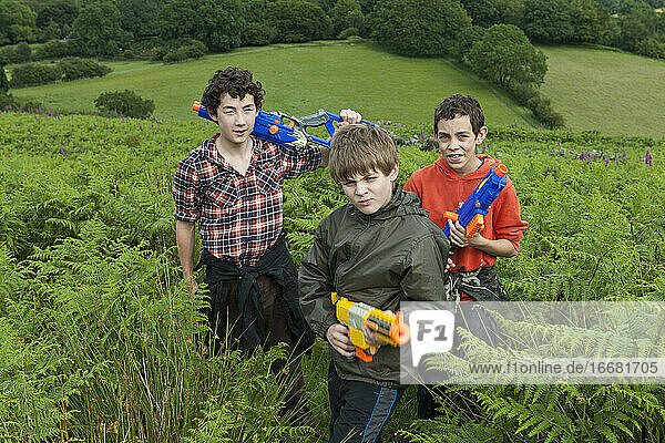 three teenage boys playing with their toy guns