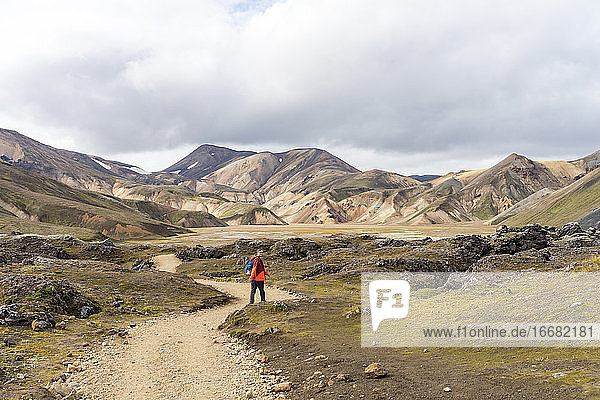 Männlicher Wanderer auf einem leeren felsigen Pfad in Island