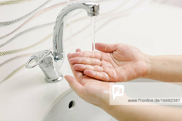 Die Frau wäscht sich die Hände mit der chirurgischen Handwaschmethode.