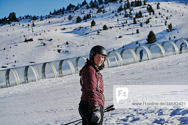 Lächelnde Frau erklimmt die Piste in einem Skifahrerband